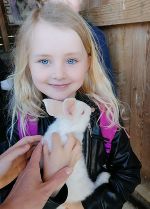 Ein ca. 5-jähriges Mädchen hält einen weißen Hasen in den Armen. Das Mädchen ist hellblond und hat sehr blaue Augen. Es lächelt und sieht glücklich aus. Ein ca. 5-jähriges Mädchen hält einen weißen Hasen in den Armen. Das Mädchen ist hellblond und hat sehr blaue Augen. Es lächelt und sieht glücklich aus.