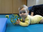Baby liegt am Bauch und hält ein Spielzeug in der Hand. Baby liegt am Bauch und hält ein Spielzeug in der Hand.