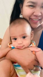 Eine Mama hält ihren Säugling im Arm, dieser lächelt verschmitzt in die Kamera. Eine Mama hält ihren Säugling im Arm, dieser lächelt verschmitzt in die Kamera.