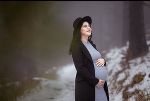 Eine Frau mit Babybauch steht in einer Winterlandschaft. Eine Frau mit Babybauch steht in einer Winterlandschaft.