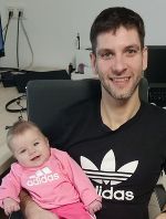 Das Foto zeigt einen Mann mit einem Baby. Beide tragen Adidas-Pullover.